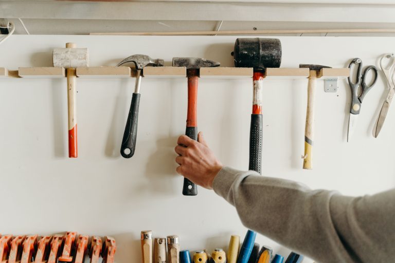 Main saisissant un marteau dans un atelier