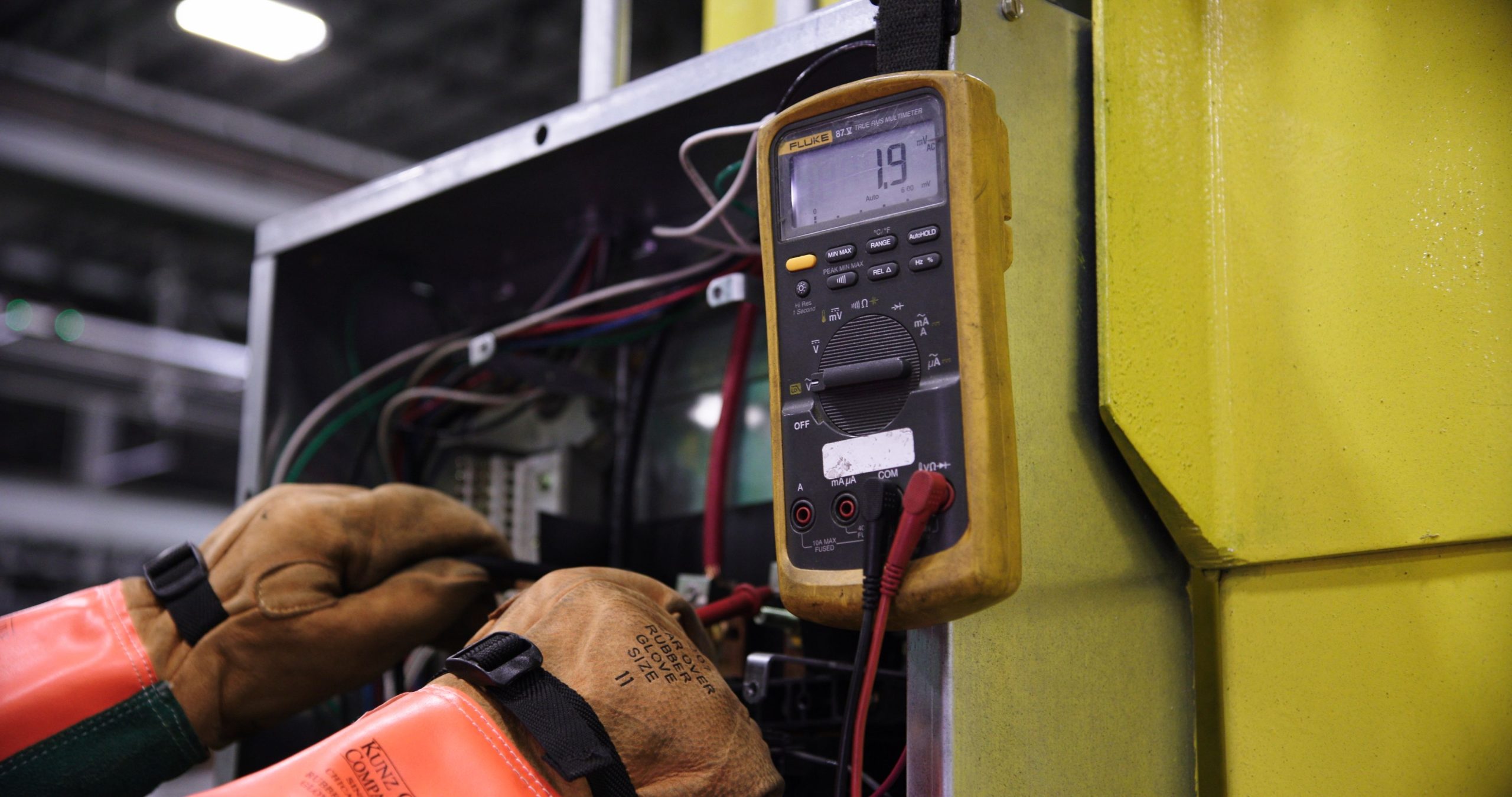 Électricien testant panneau électrique industriel