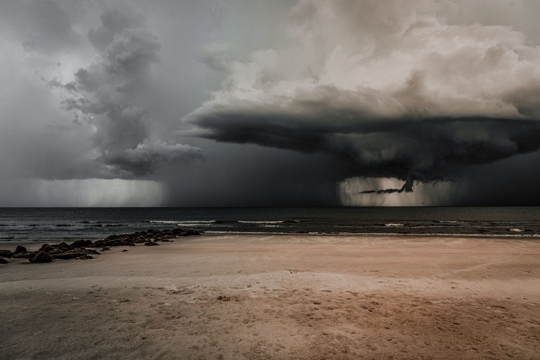 Nuages orageux sombres sur plage déserte