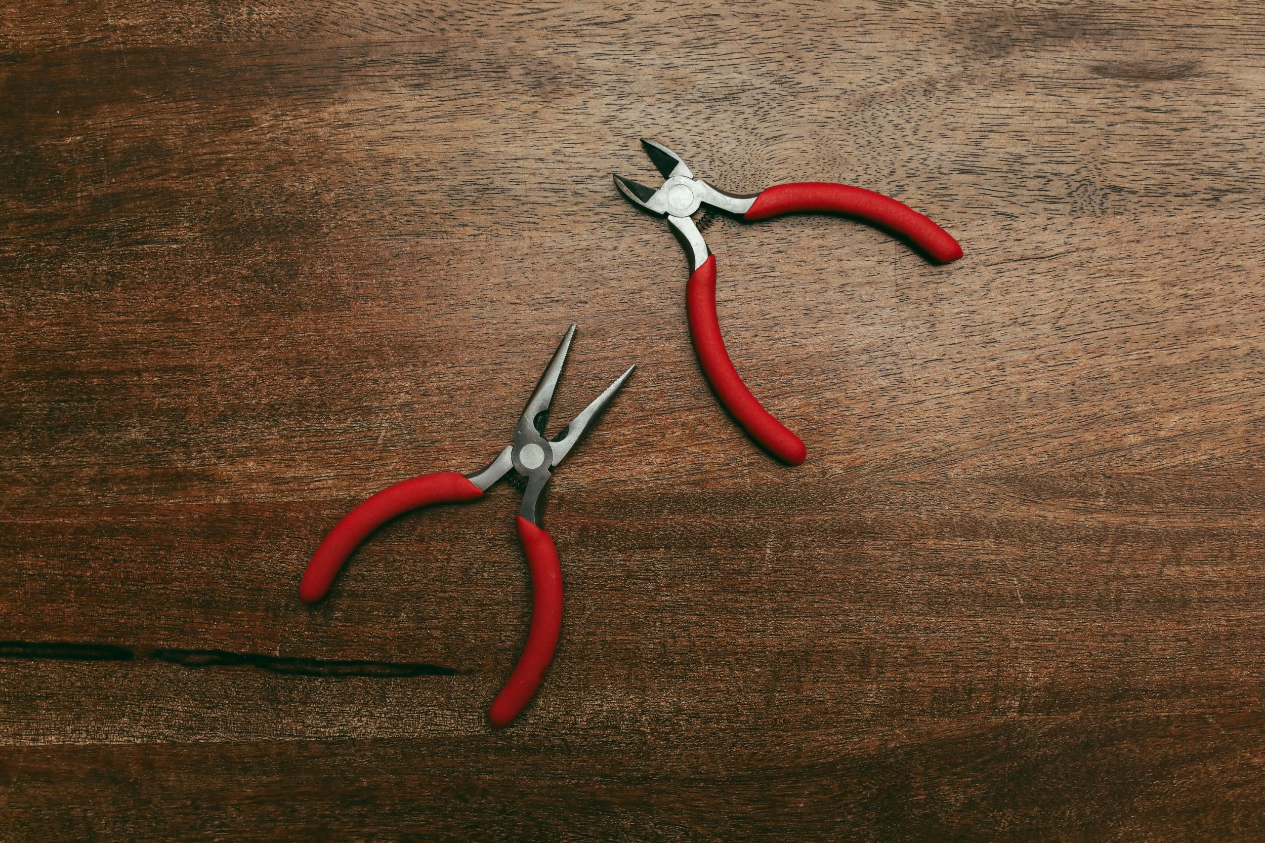 Pinces à bec long rouge surface bois travail