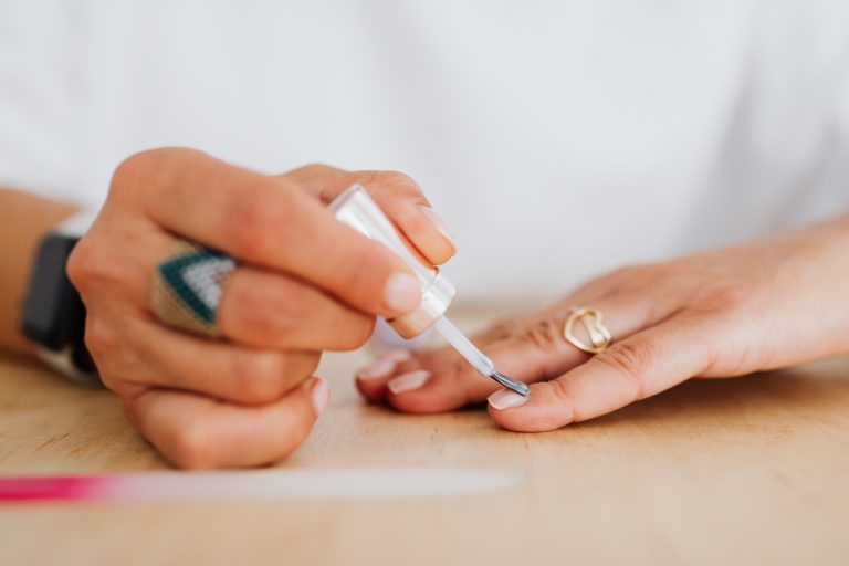 Femme appliquant vernis transparent pour manucure soignée