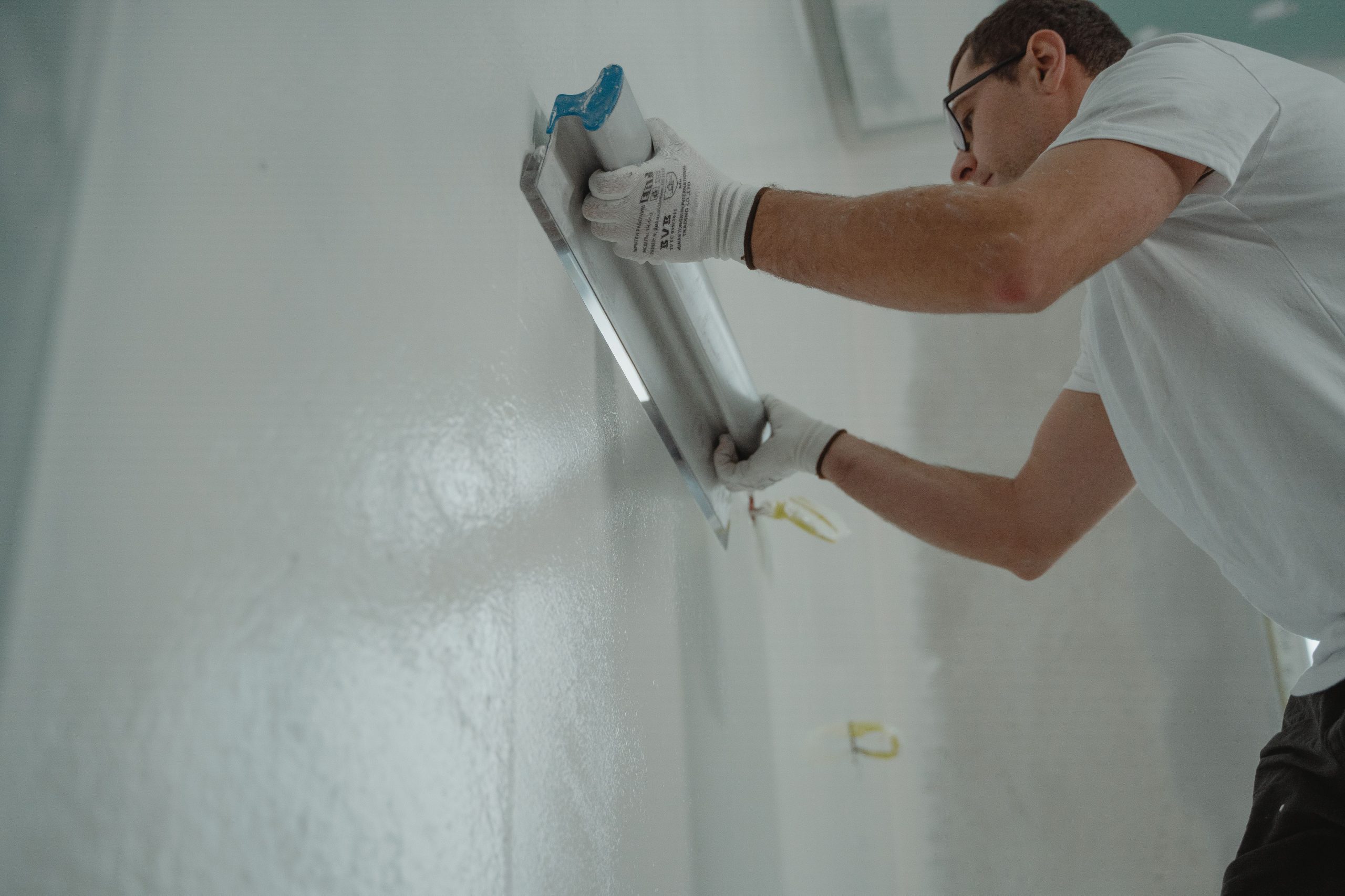 Ouvrier appliquant enduit mur intérieur lisse