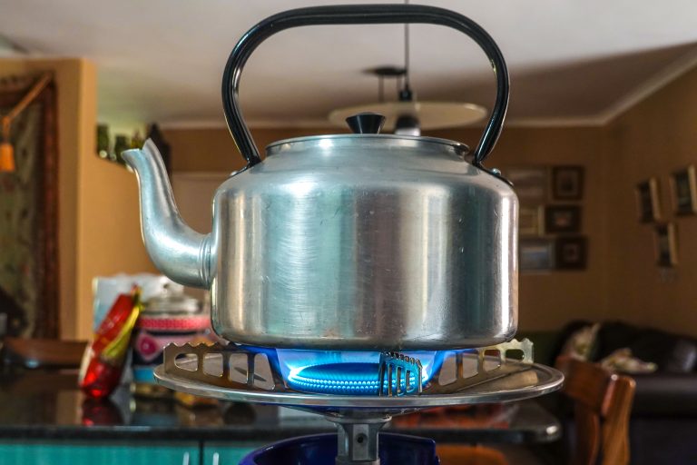 Bouilloire inox chauffant sur cuisinière gaz