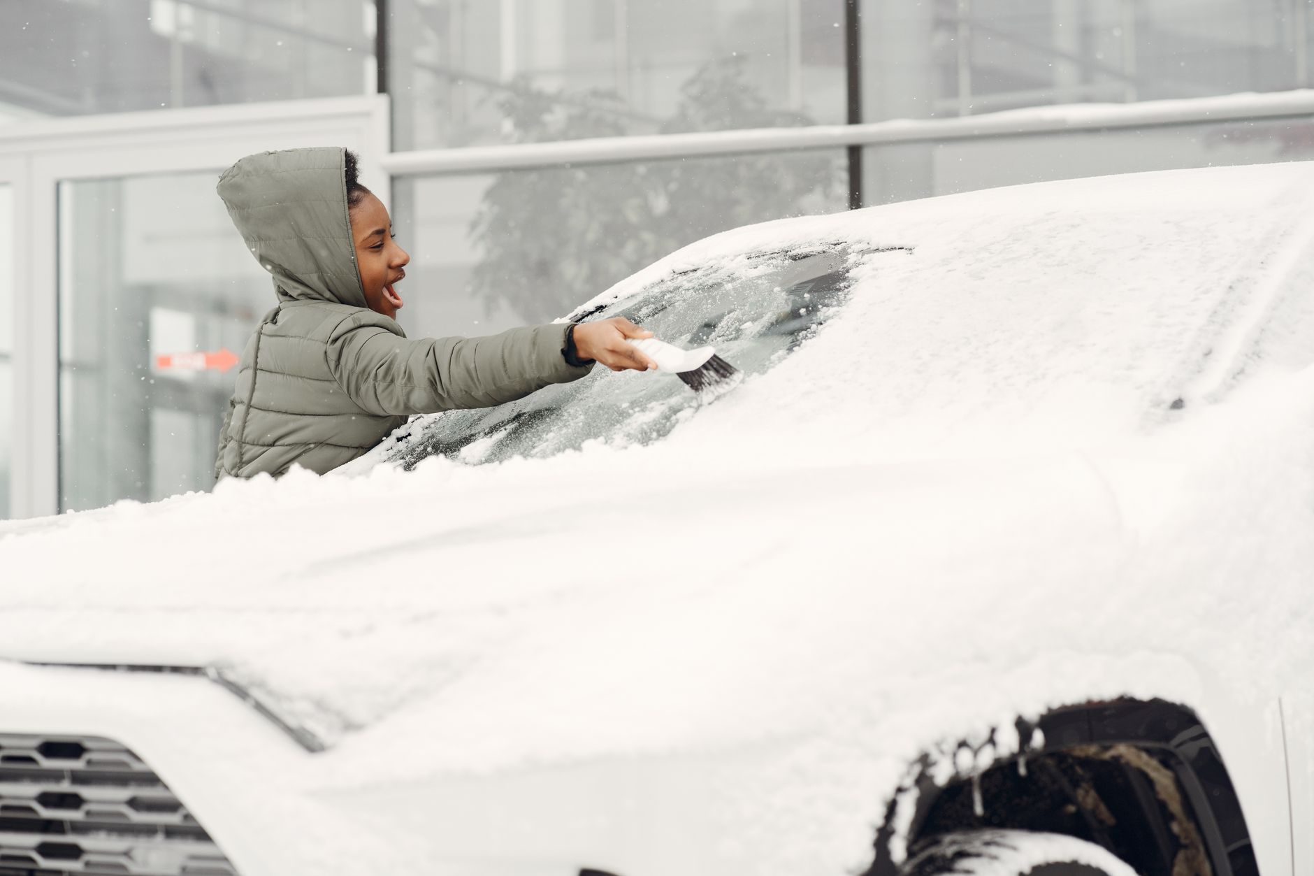 Femme degageant neige pare-brise hiver