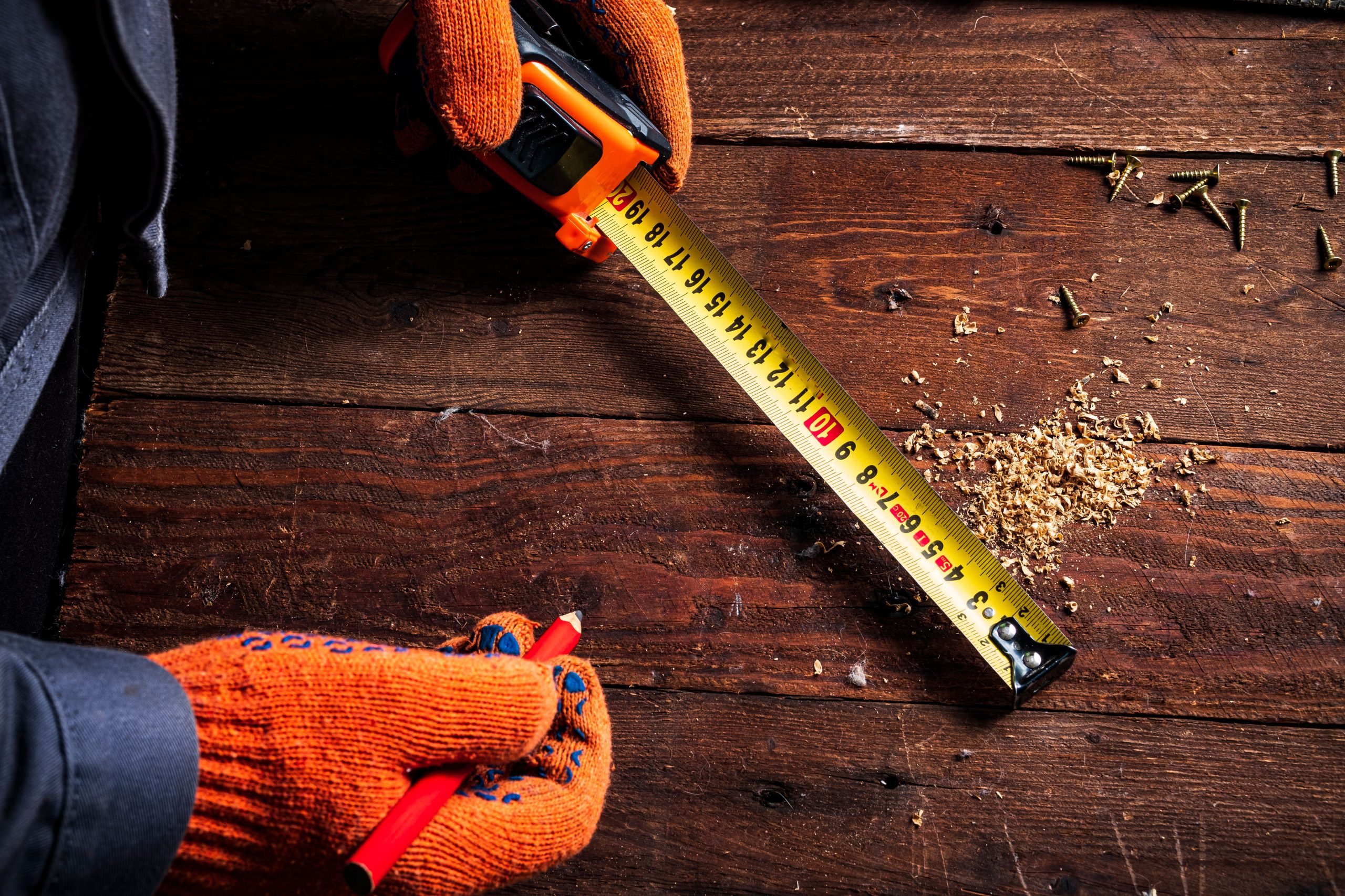 Mains gantées mesurant bois avec mètre ruban