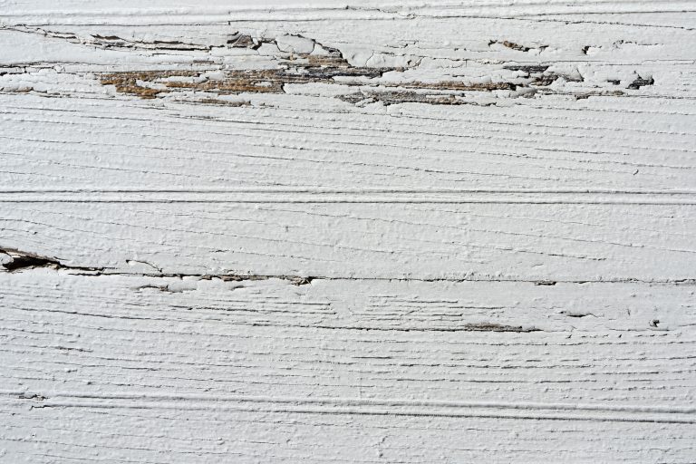 Peinture blanche écaillée sur surface bois