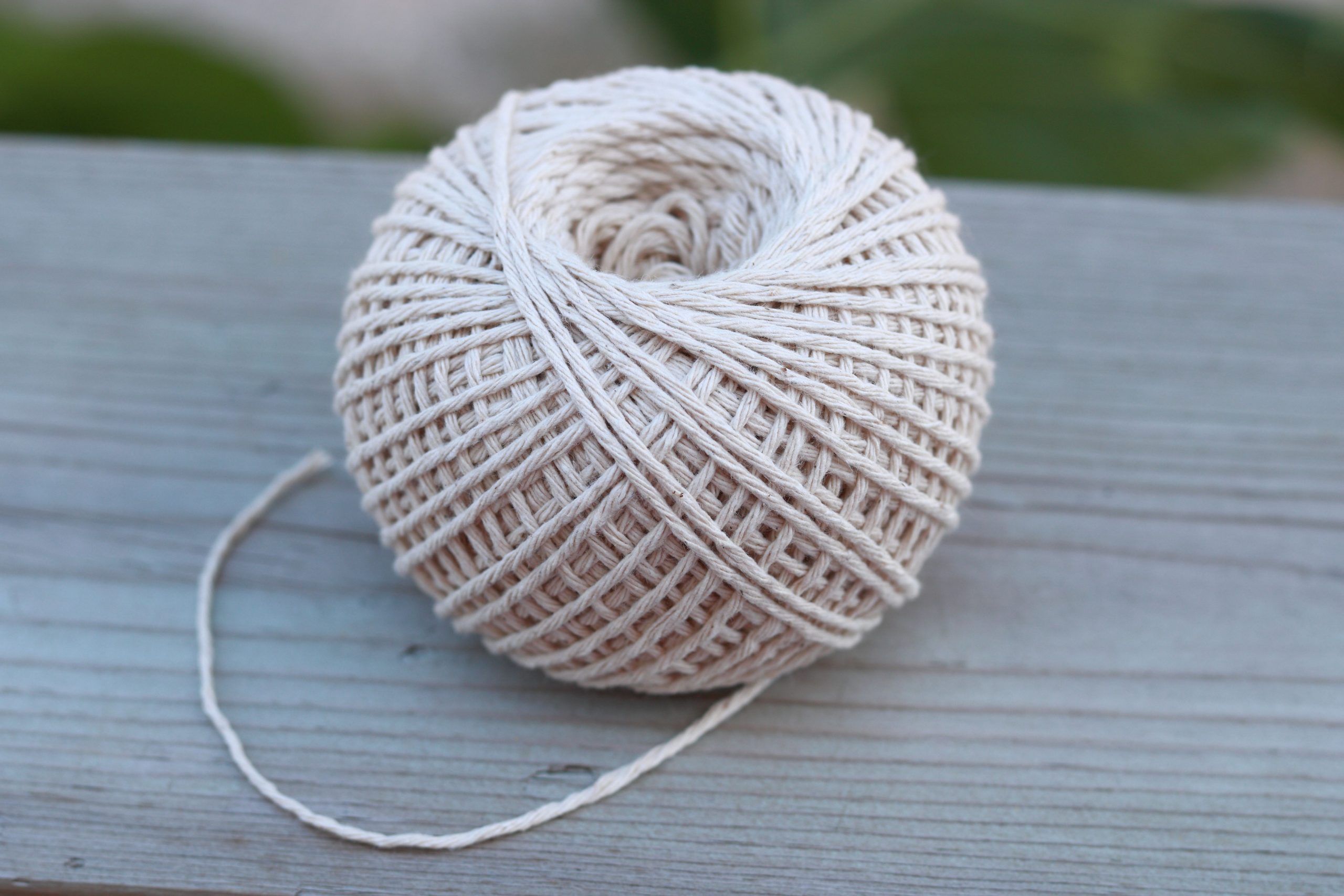 Pelote de ficelle beige sur surface bois