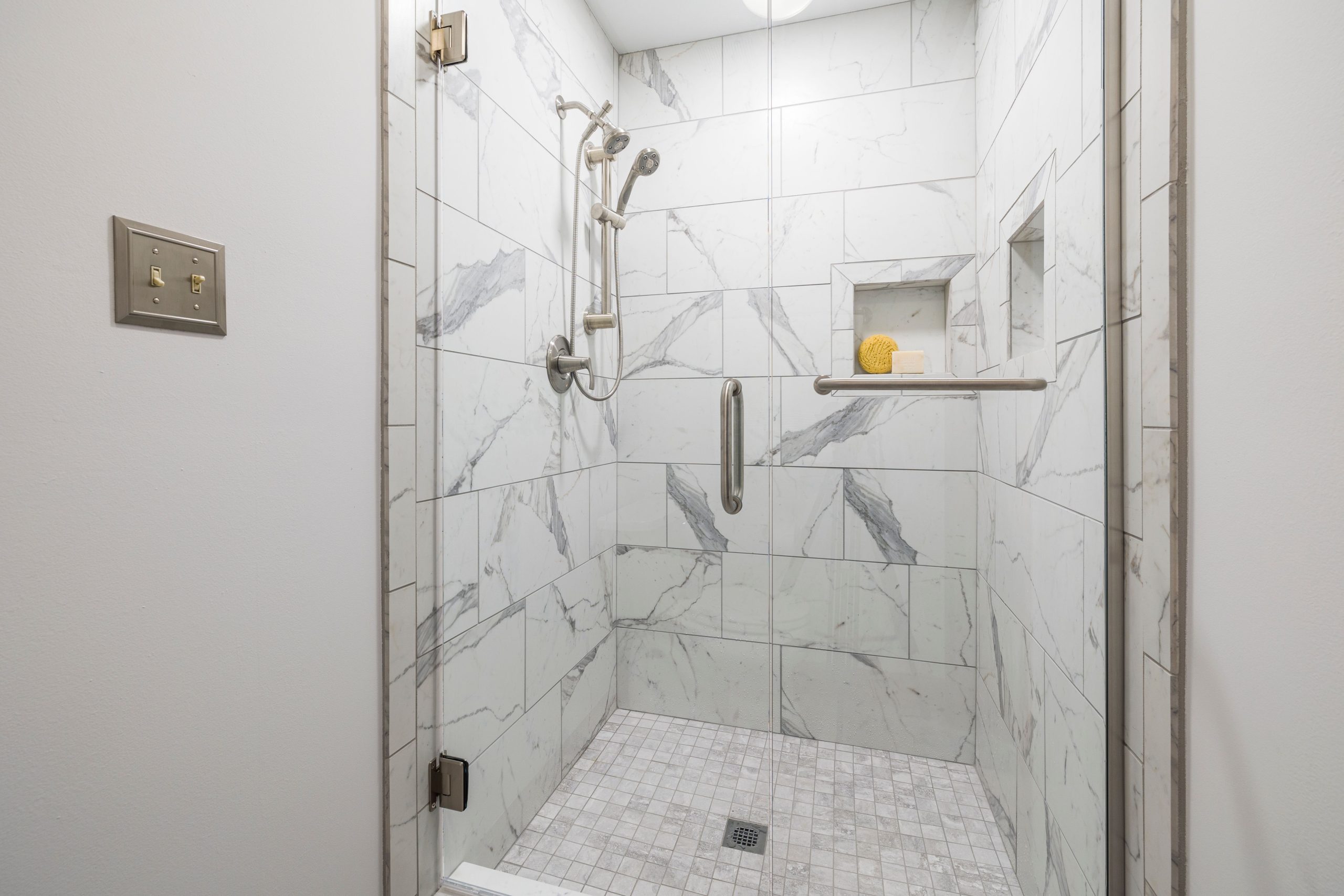 Salle de bain élégante avec marbre blanc et paroi vitrée