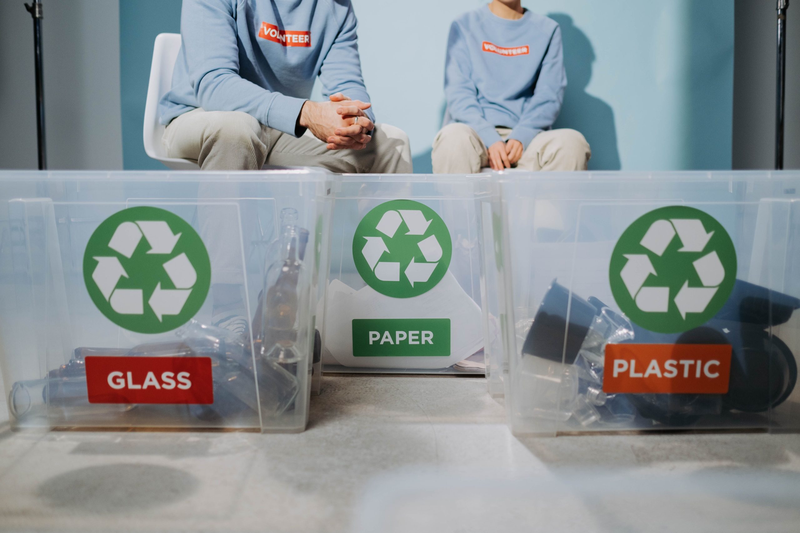Bénévoles trient recyclables dans poubelles verre papier plastique