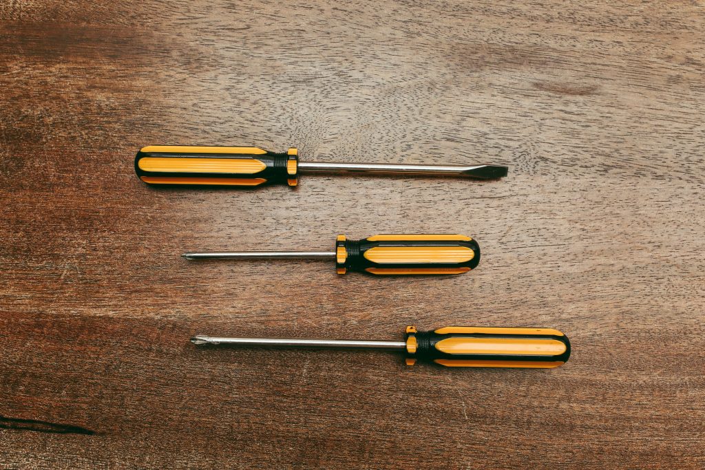 Trois tournevis cruciformes sur table en bois