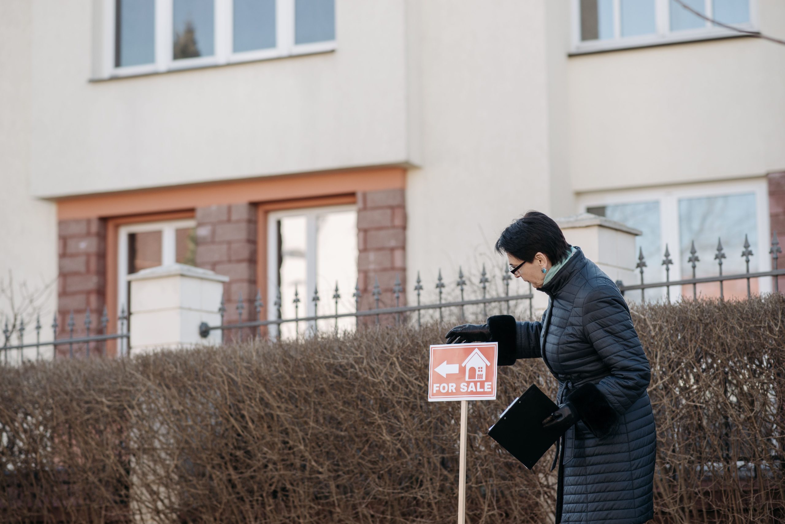 Agent immobilier plante une pancarte à vendre