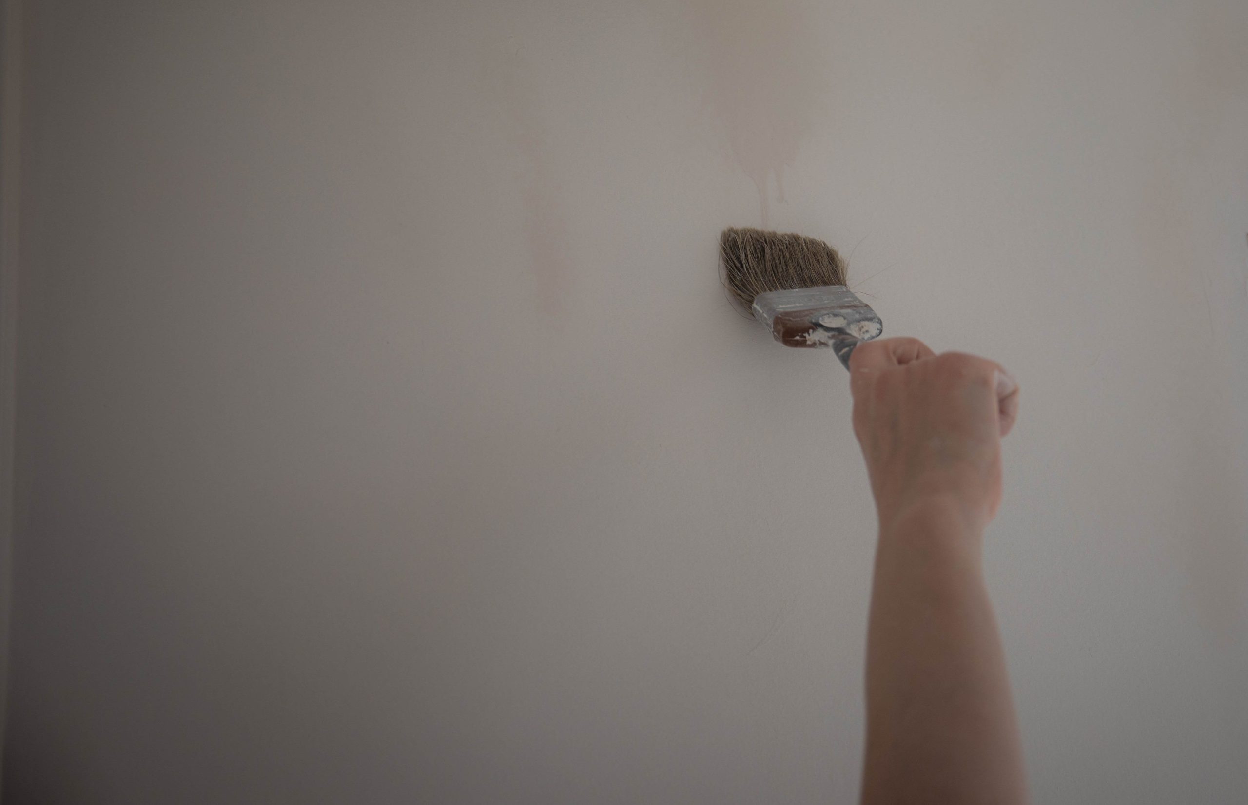 Pinceau appliquant peinture sur mur intérieur