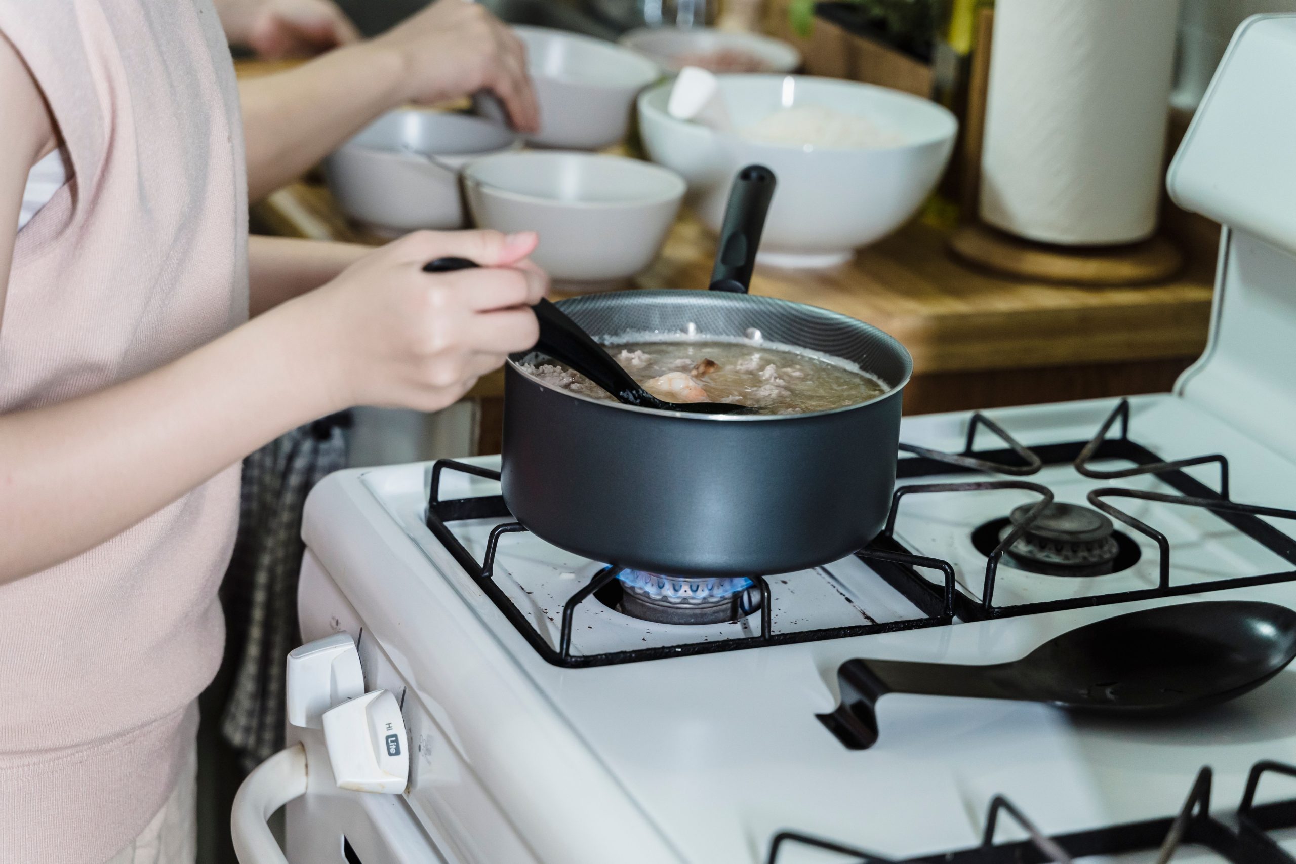 Femme versant une louche de soupe chaude à la cuisine