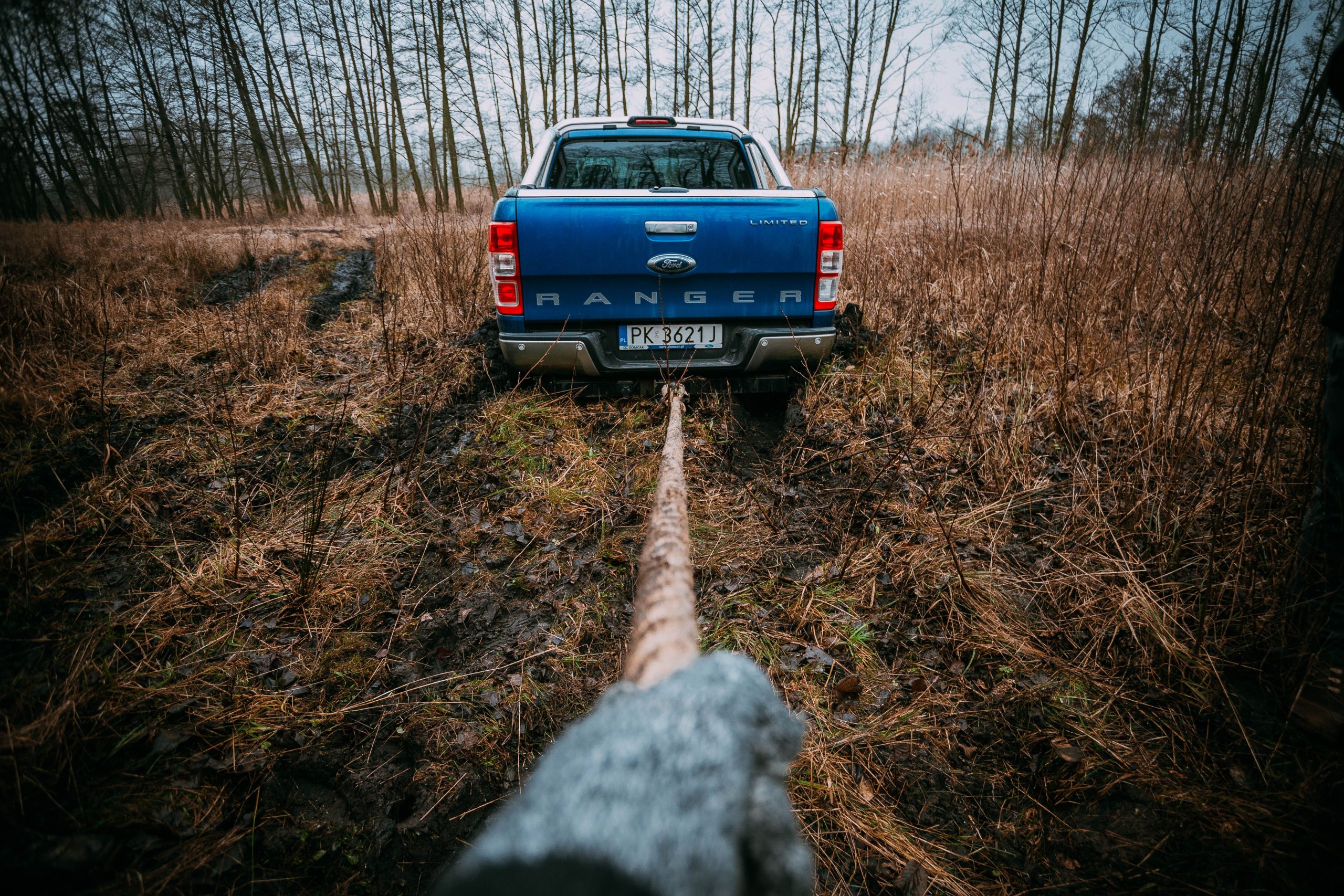 Ford Ranger bleu remorqué en terrain boueux