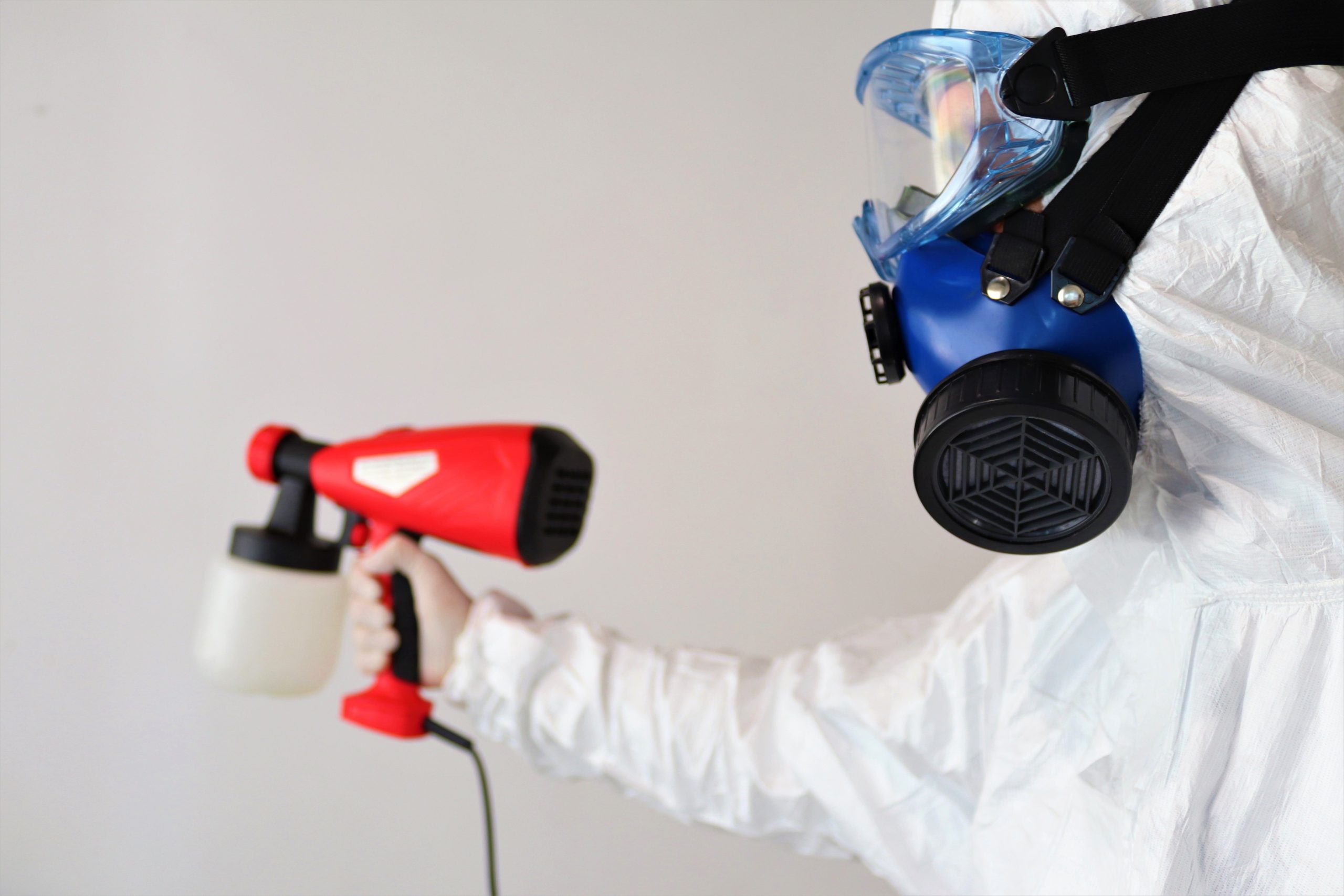 Professionnel en tenue pulvérisant désinfectant intérieur