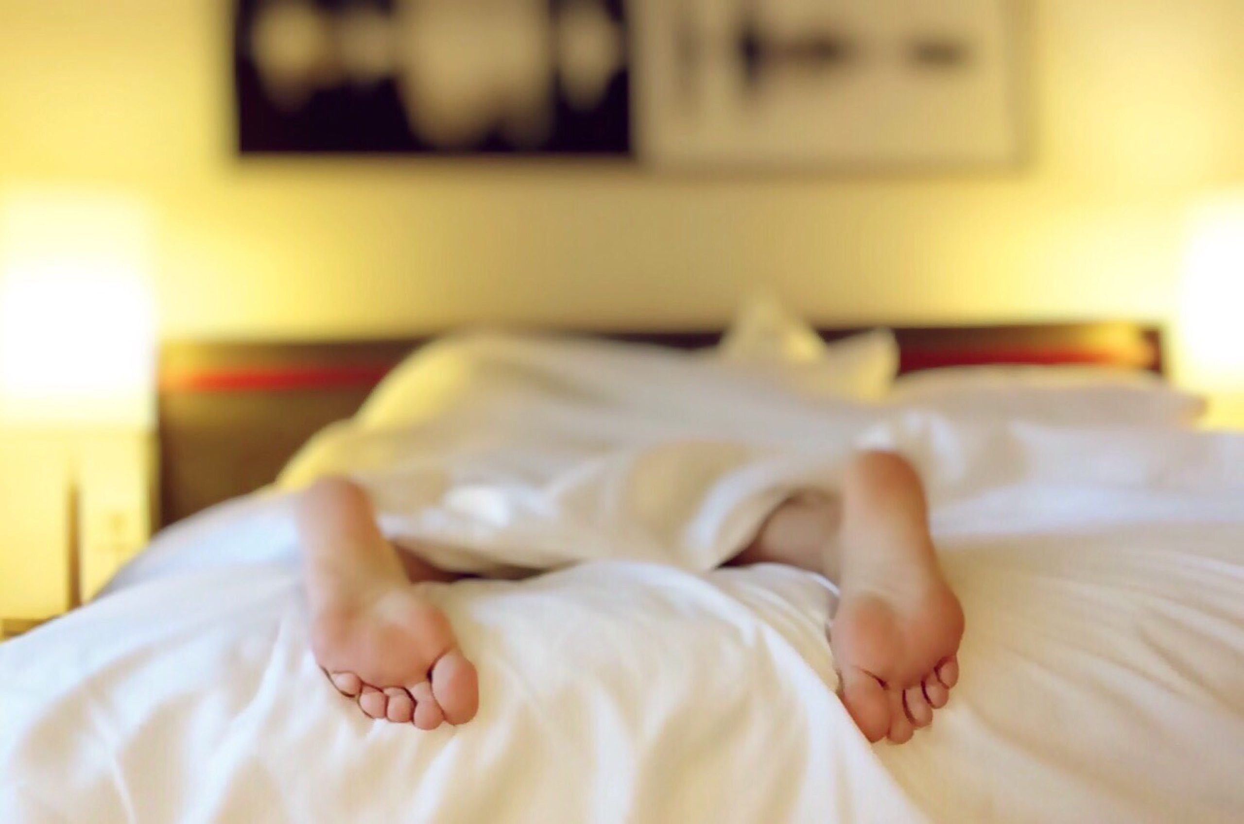 Personne détendue allongée sous des draps blancs