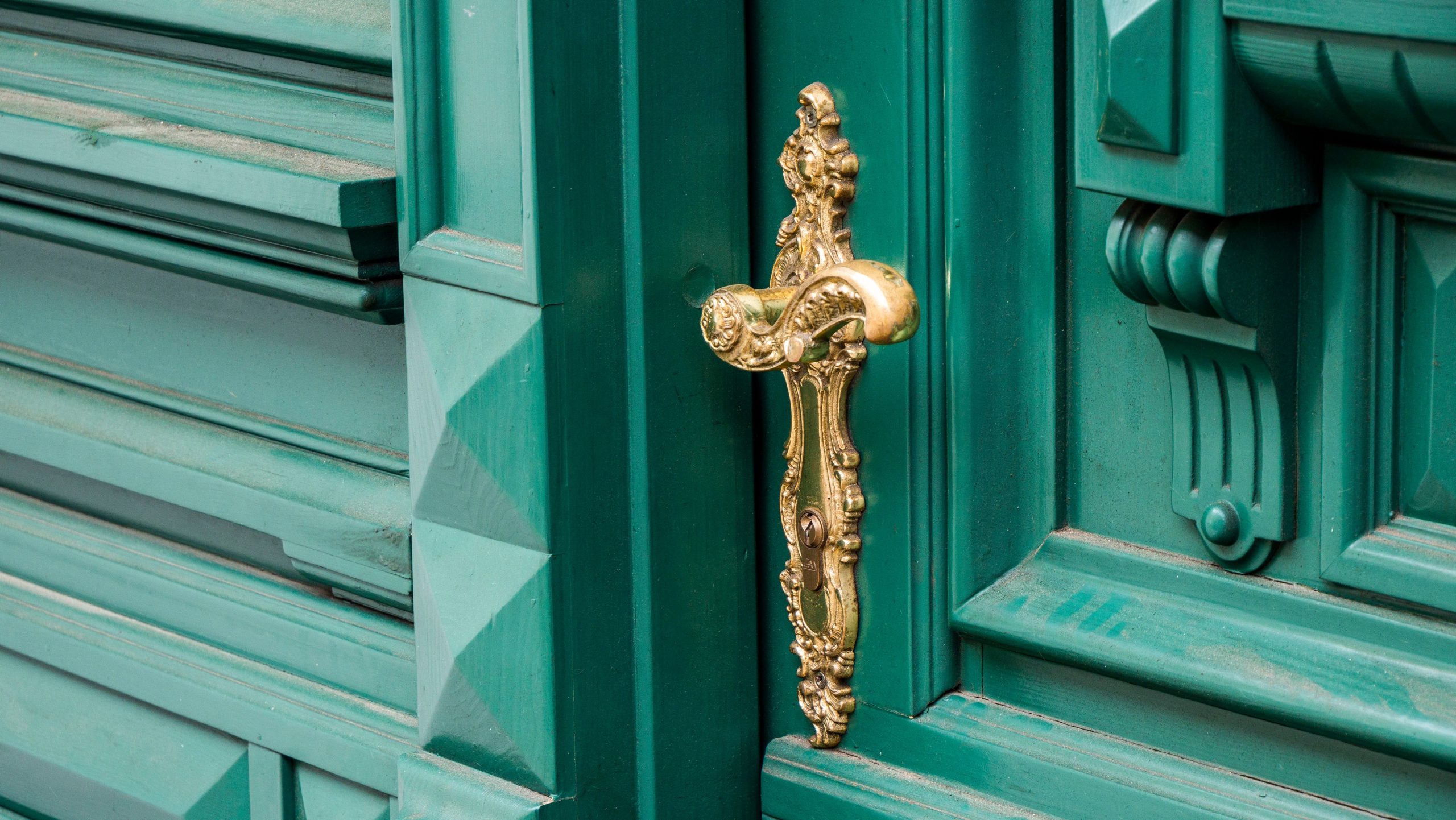 Poignée laiton ornée sur porte turquoise