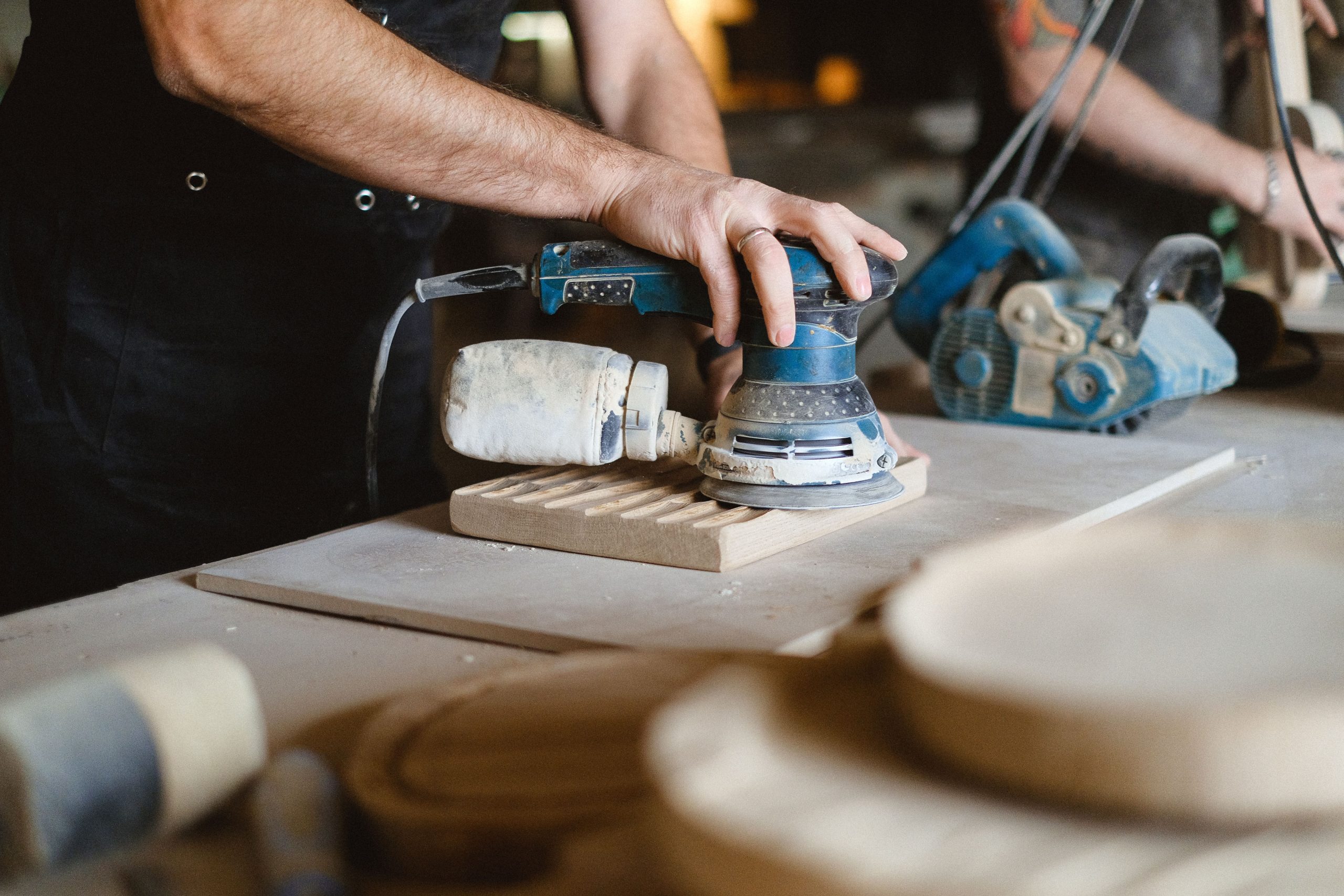 Professionnel utilisant ponceuse orbitale sur bois