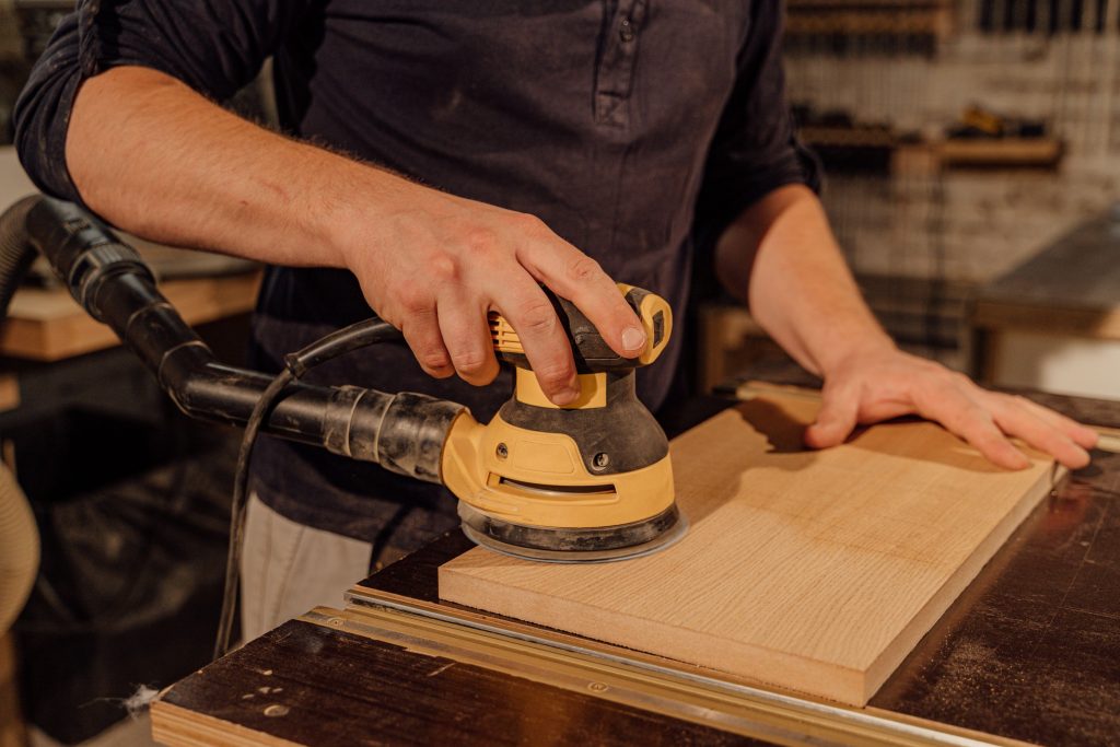 Menuisier ponçant une planche en bois